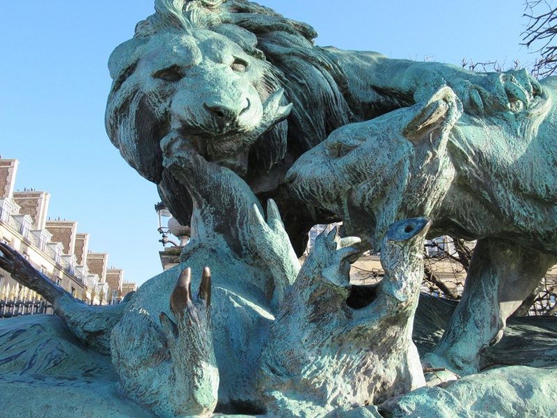 large lion and lioness fighting over a boar