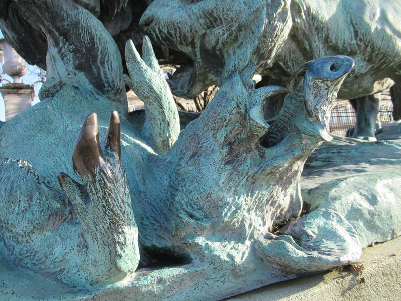 lion and lioness fighting over a boar sculpture