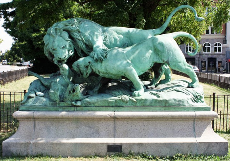 outdoor lion and lioness fighting over a boar